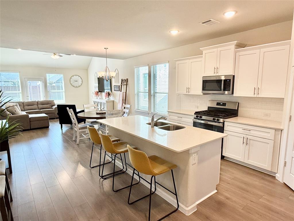 603 Hazeltine Road Red Oak, TX 75154 - Photo 8 of 37 a kitchen with a stove a sink and a refrigerator