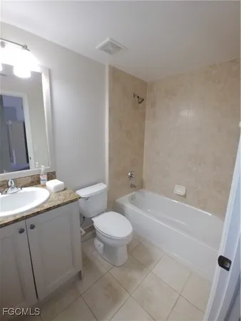 a bathroom with a granite countertop sink toilet mirror and bathtub