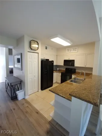 a kitchen with stainless steel appliances granite countertop a refrigerator a stove and a sink