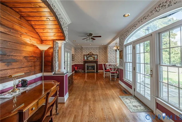 a living room with furniture a wooden floor and next to a window