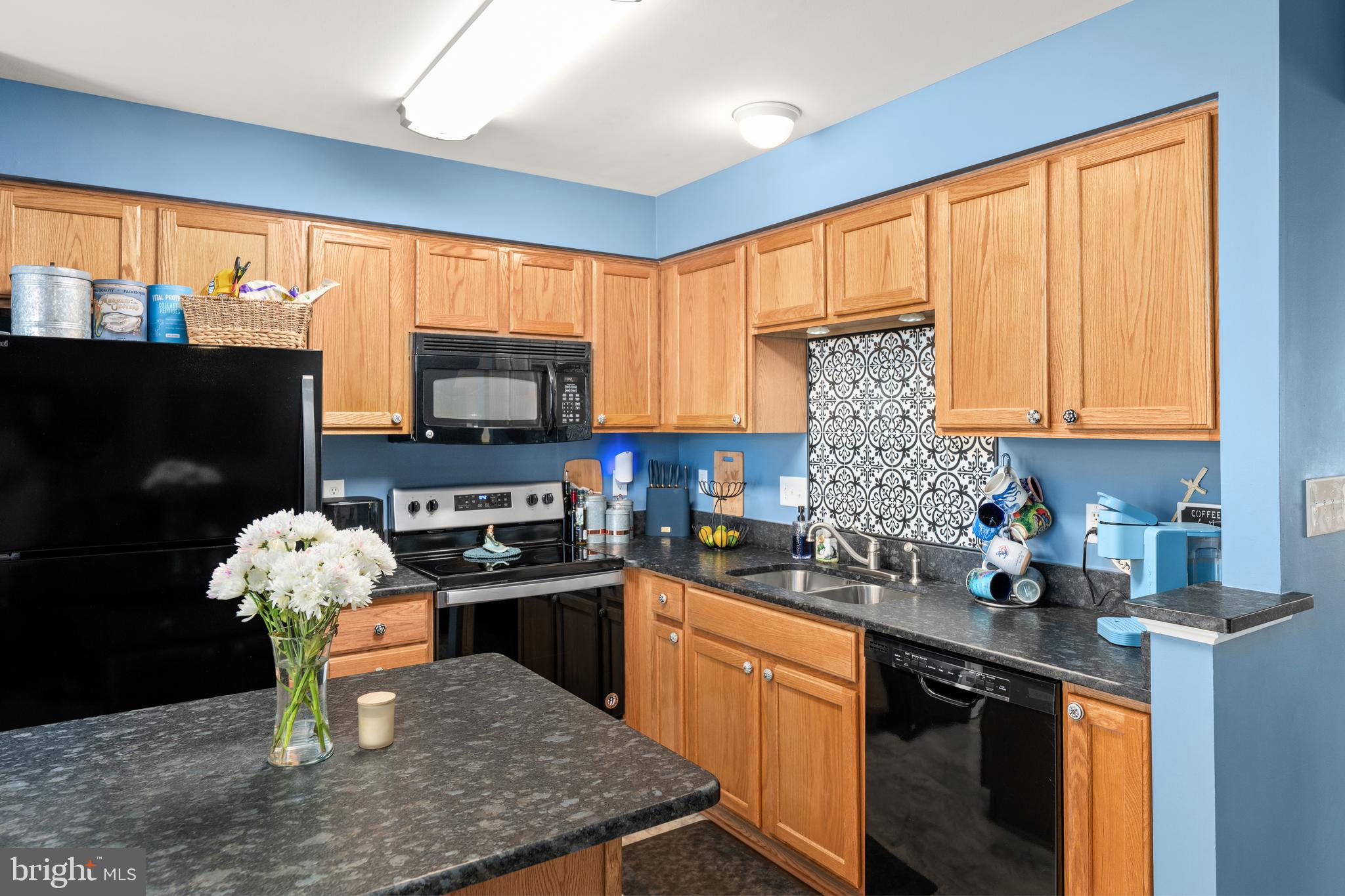 27548 Mayfield Road, Unit 42 Millsboro, DE 19966 - Photo 11 of 46 a kitchen with stainless steel appliances granite countertop a stove sink and cabinets