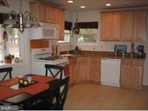 25 North Island Road Bayville, NJ 08721 - Photo 2 of 5 a kitchen with stainless steel appliances granite countertop a stove top oven a sink a refrigerator and white cabinets