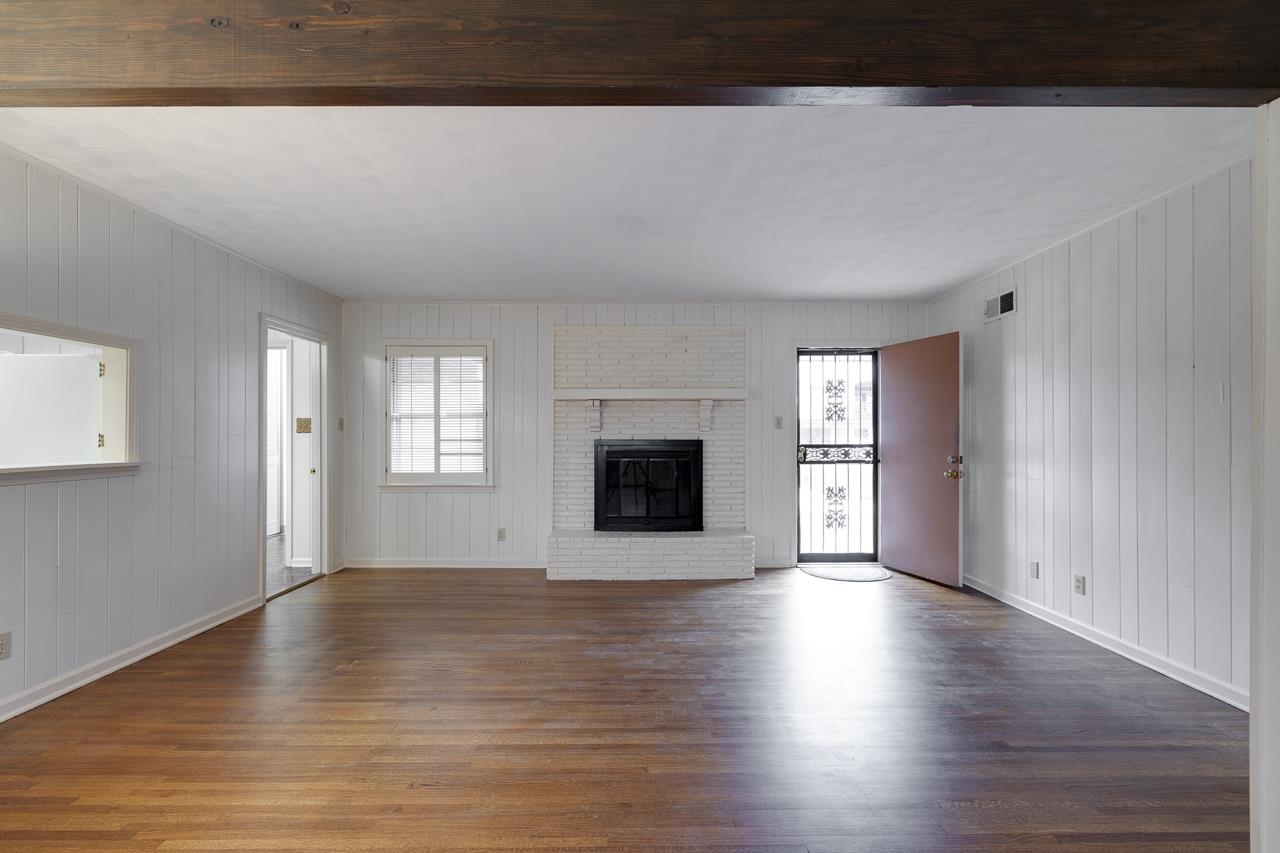 5673 Normandy Road Memphis, TN 38120 - Photo 12 of 39 a view of an empty room with window and wooden floor