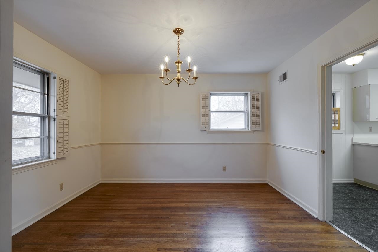 5673 Normandy Road Memphis, TN 38120 - Photo 14 of 39 an empty room with wooden floor and windows