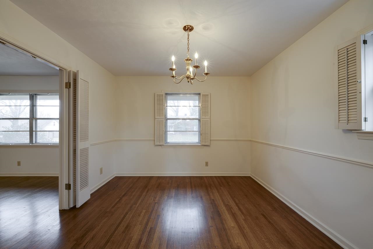 5673 Normandy Road Memphis, TN 38120 - Photo 15 of 39 an empty room with wooden floor and windows