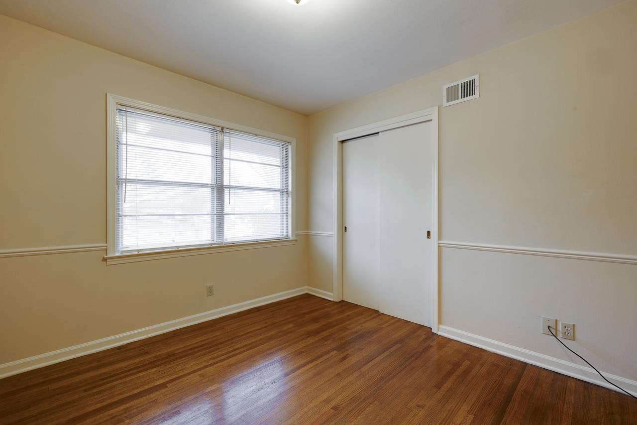5673 Normandy Road Memphis, TN 38120 - Photo 24 of 39 an empty room with wooden floor and windows