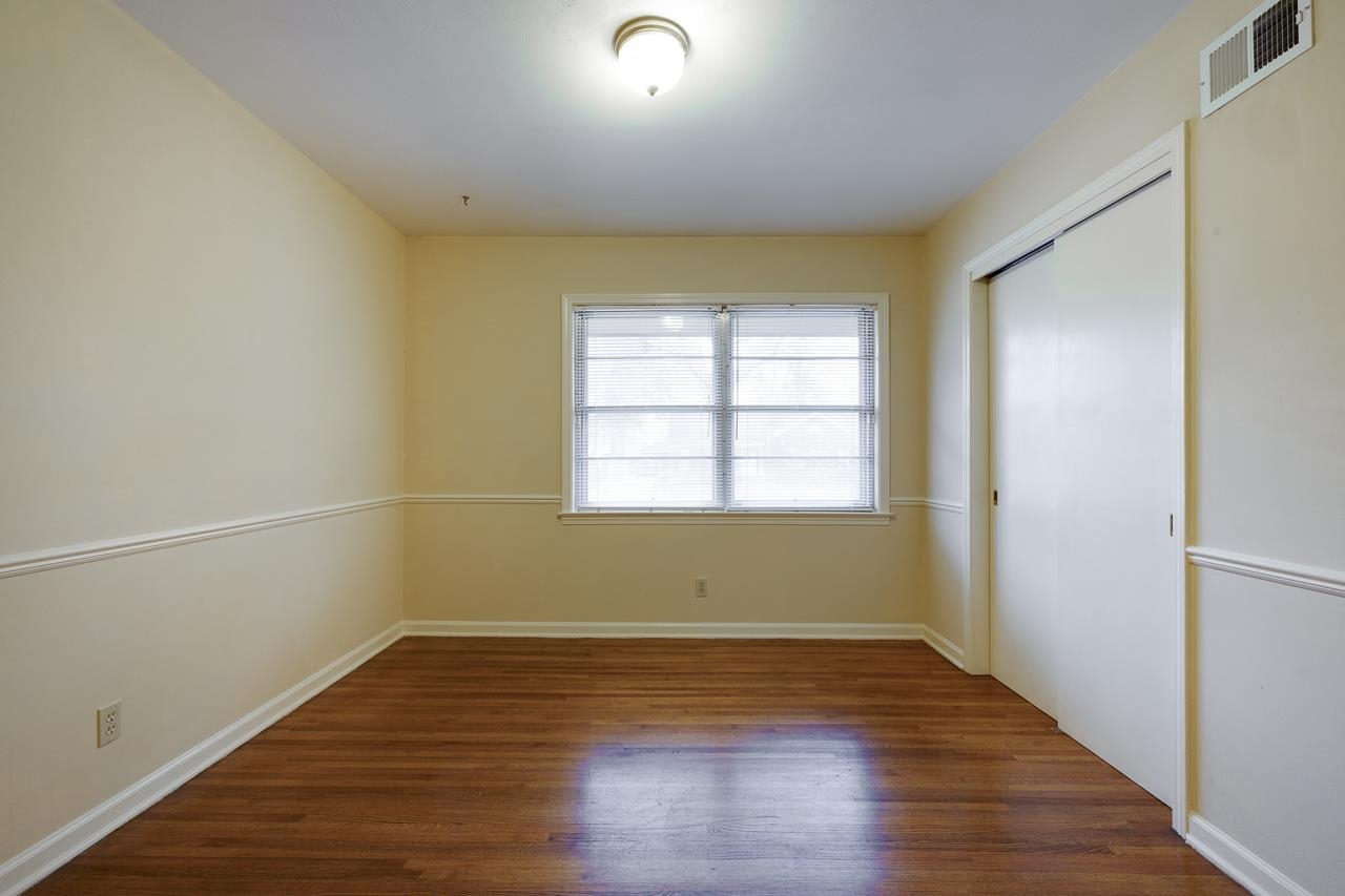 5673 Normandy Road Memphis, TN 38120 - Photo 25 of 39 an empty room with wooden floor and windows