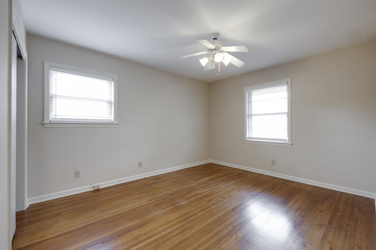 5673 Normandy Road Memphis, TN 38120 - Photo 26 of 39 a view of an empty room with wooden floor and a window