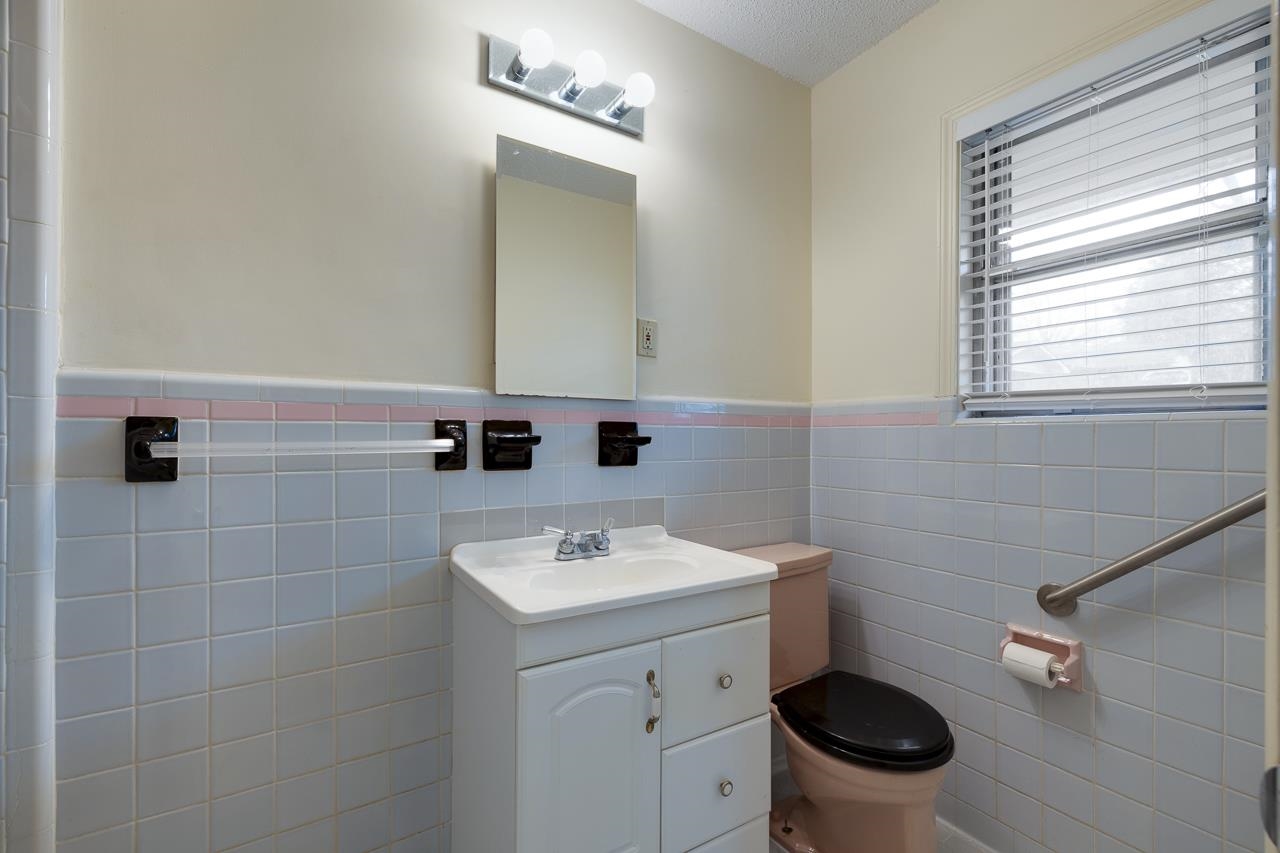 5673 Normandy Road Memphis, TN 38120 - Photo 28 of 39 a bathroom with a toilet a sink and mirror