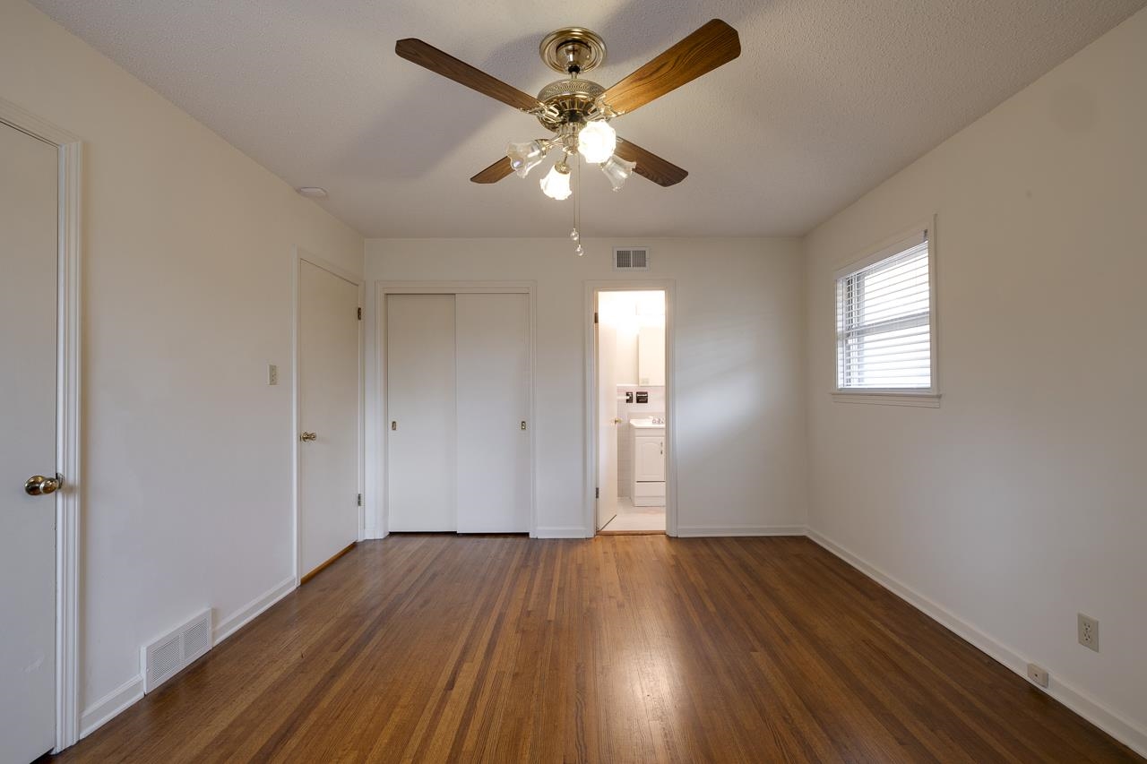 5673 Normandy Road Memphis, TN 38120 - Photo 29 of 39 wooden floor in an empty room with a window