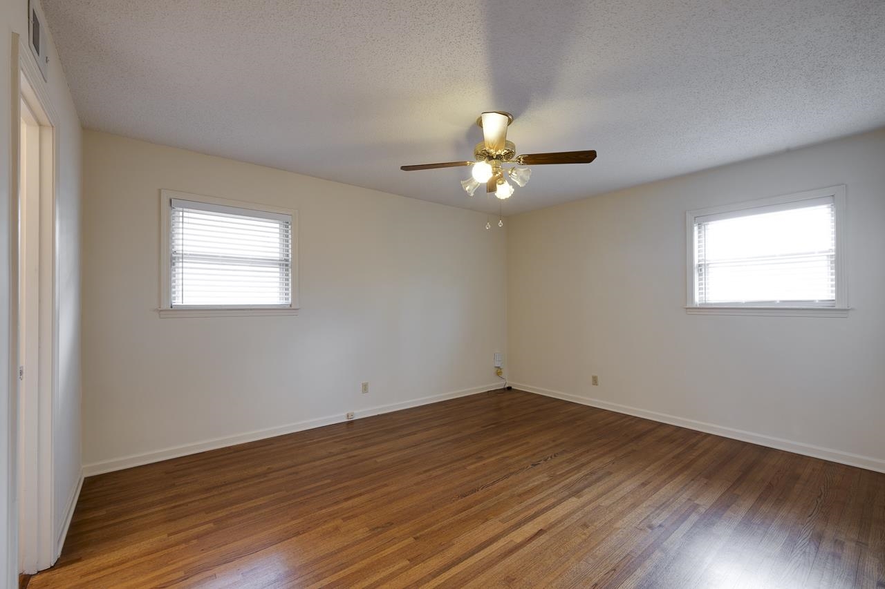 5673 Normandy Road Memphis, TN 38120 - Photo 30 of 39 a view of an empty room with wooden floor and a window