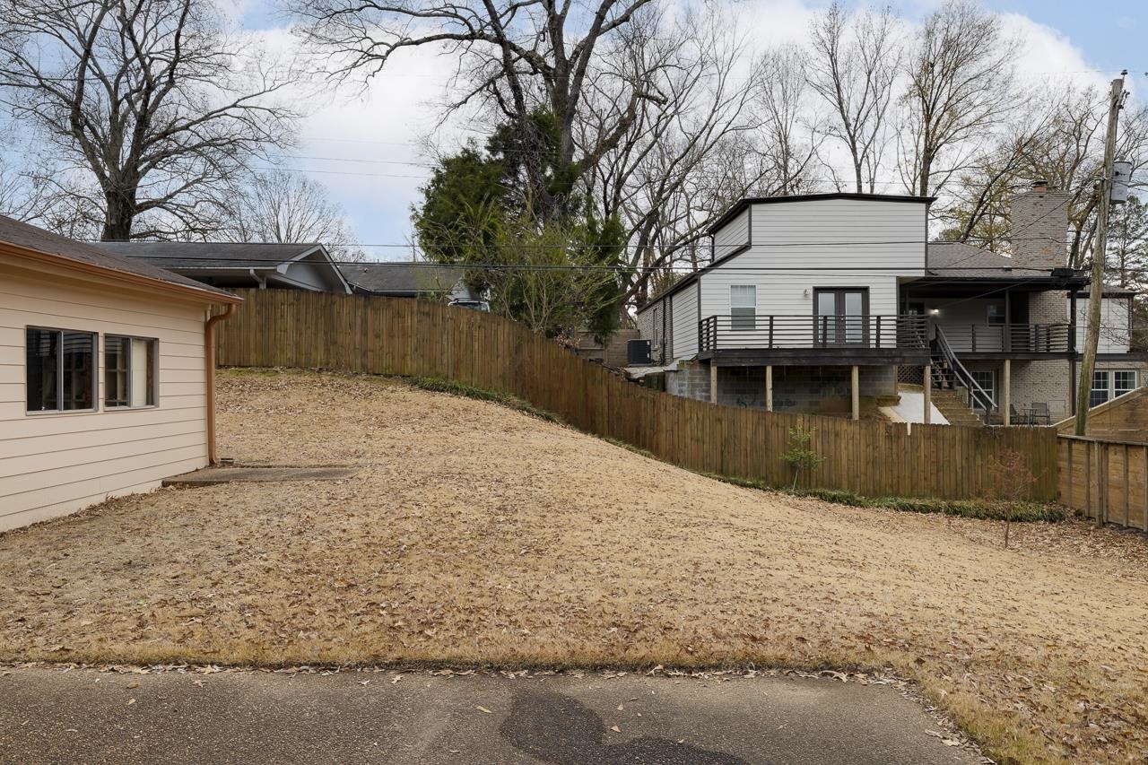 5673 Normandy Road Memphis, TN 38120 - Photo 34 of 39 a backyard of a house with large trees and outdoor seating