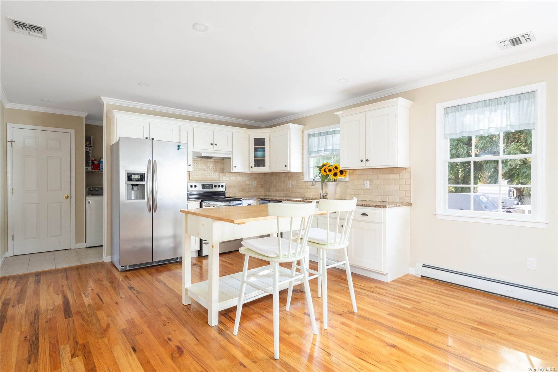 115 Cliff Road Wading River, NY 11792 - Photo 6 of 28 a kitchen with stainless steel appliances refrigerator wooden floor dining table and chair