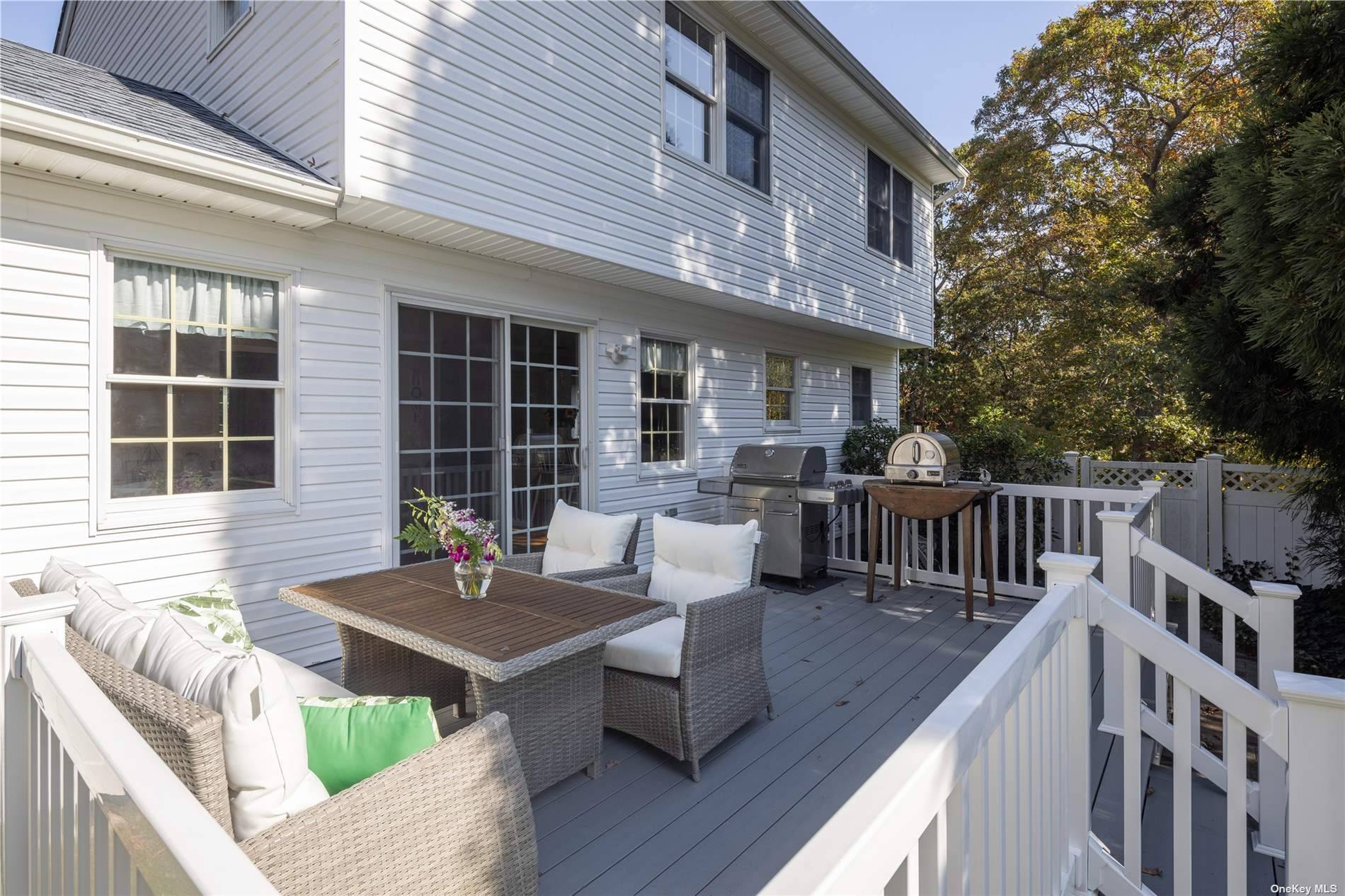 115 Cliff Road Wading River, NY 11792 - Photo 9 of 28 a view of a deck with couches table and chairs and wooden floor