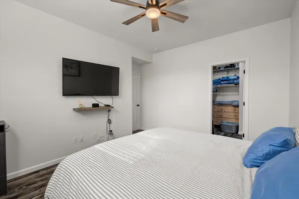 a bedroom with a bed and a flat tv screen on wall