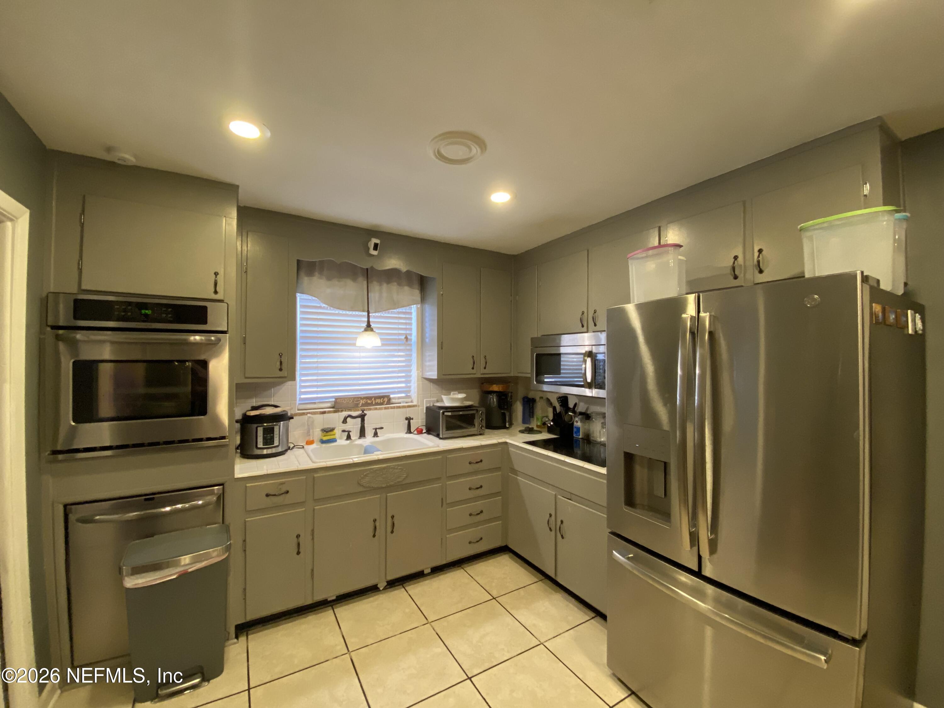 6400 Diane Road Jacksonville, FL 32277 - Photo 3 of 16 a kitchen with refrigerator cabinets and microwave