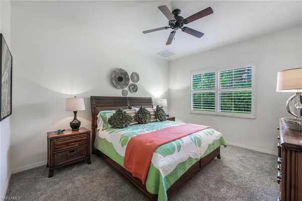 a bedroom with a bed a window and a chandelier