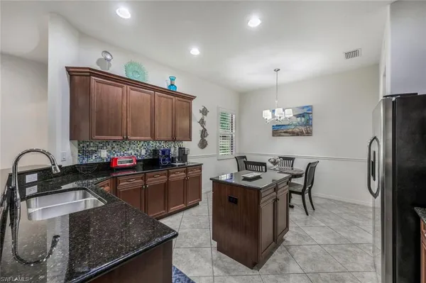a kitchen with granite countertop a sink stove and refrigerator