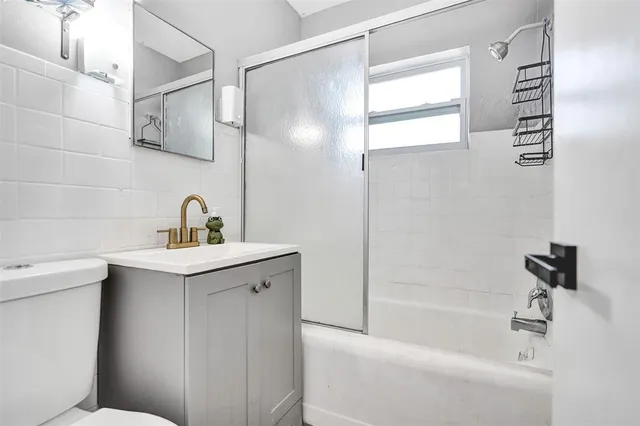 a bathroom with a sink and mirror with bathtub