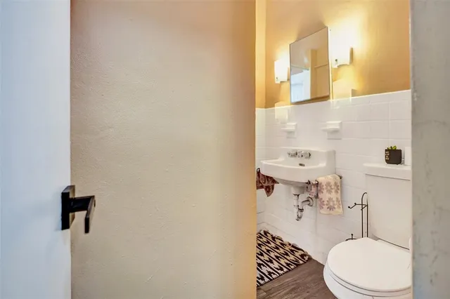 a bathroom with a sink a toilet a mirror and shower