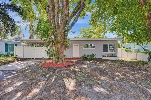 a view of a house with backyard and tree