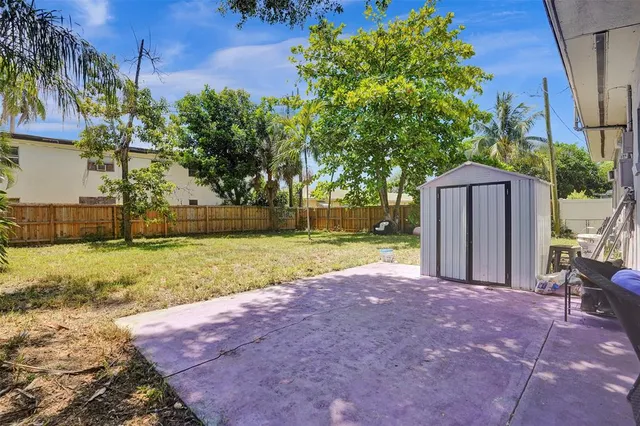 a view of a house with backyard and a tree