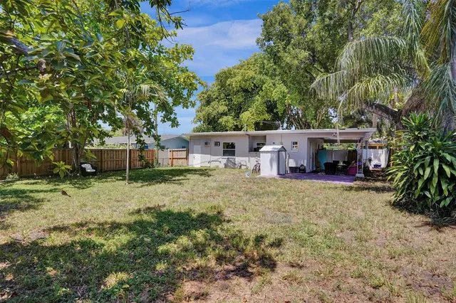 a view of a house with backyard and a tree