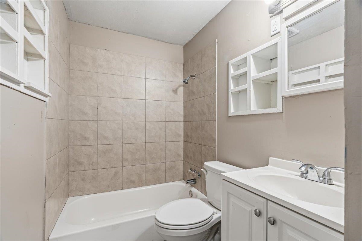 1176 South White Station Road Memphis, TN 38117 - Photo 13 of 15 Bathroom featuring a white bathtub, ceramic wall tiling, white vanity with integrated sink, chrome faucet, and white framed medicine cabinet