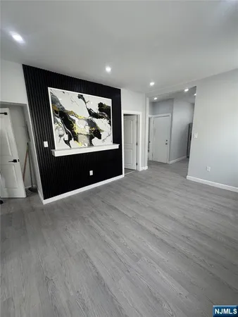 an empty room with wooden floor and painting on the wall