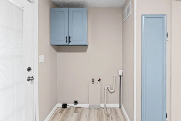a hallway with white cabinets and wooden floor
