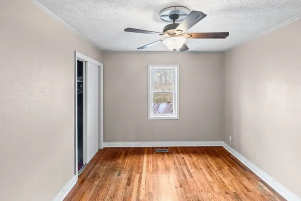 a view of an empty room with wooden floor