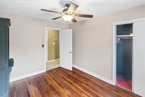 an empty room with a window and ceiling fan
