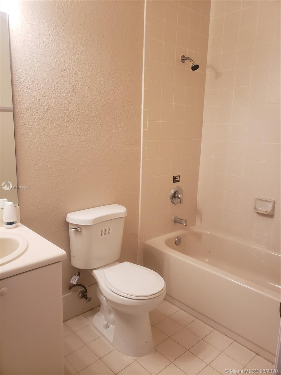 2551 Southeast 16th Terrace, Unit 104 Homestead, FL 33035 - Photo 3 of 7 a white toilet and tub sitting next to a bathroom sink
