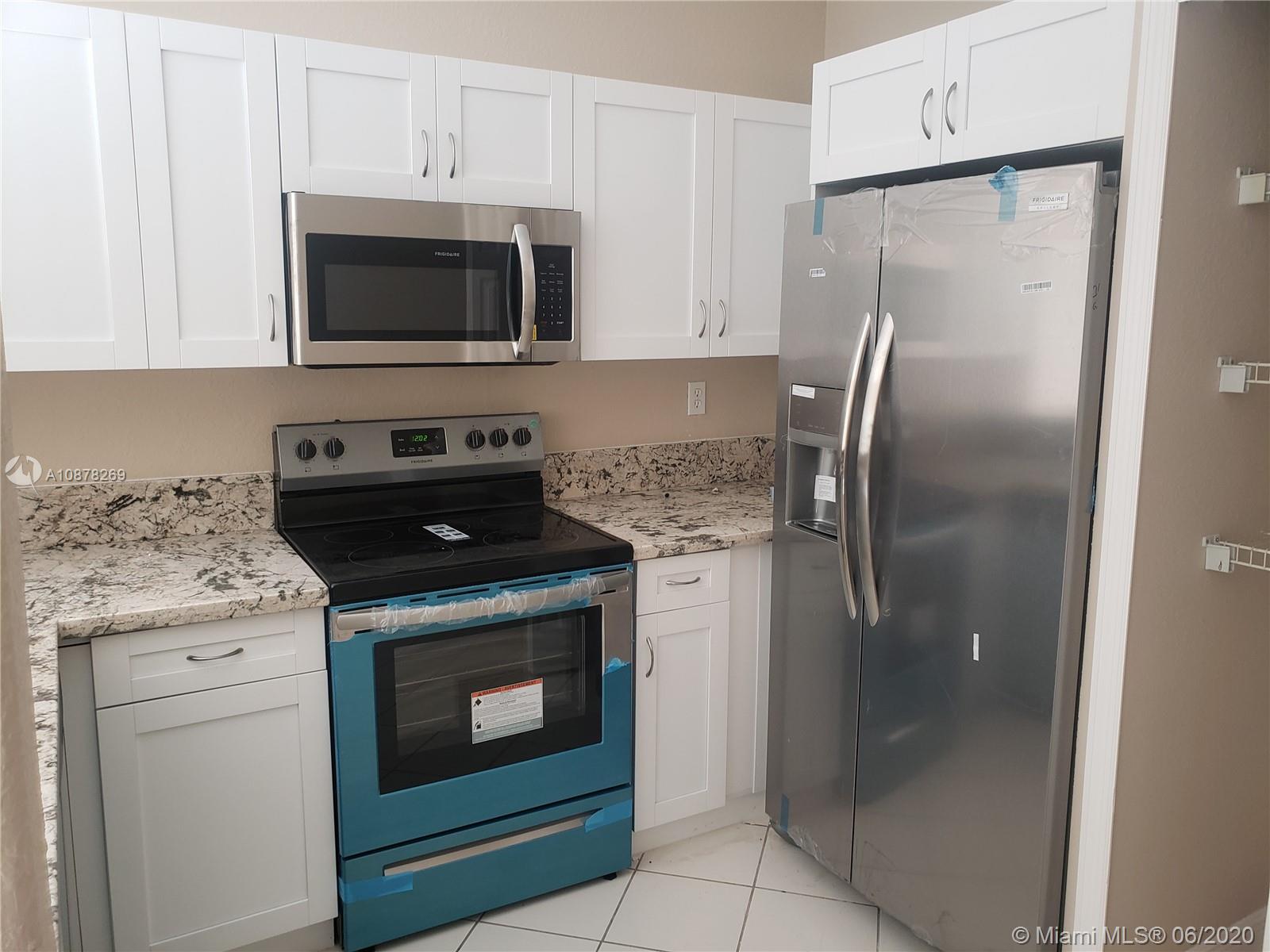 2551 Southeast 16th Terrace, Unit 104 Homestead, FL 33035 - Photo 6 of 7 a kitchen with a stove microwave and refrigerator
