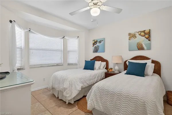 a bedroom with two beds and painting on the wall