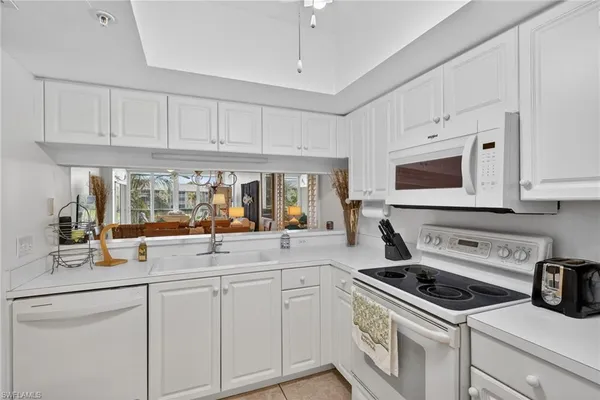 a kitchen with white cabinets and white appliances