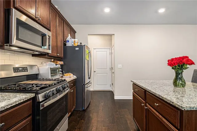 a kitchen with stainless steel appliances granite countertop a sink stove and refrigerator