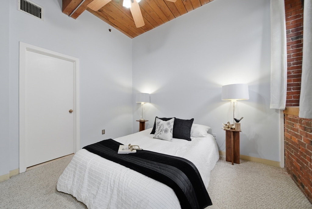 50 Rantoul Street, Unit 204 Beverly, MA 01915 - Photo 13 of 41 a bedroom with a bed and a lamp