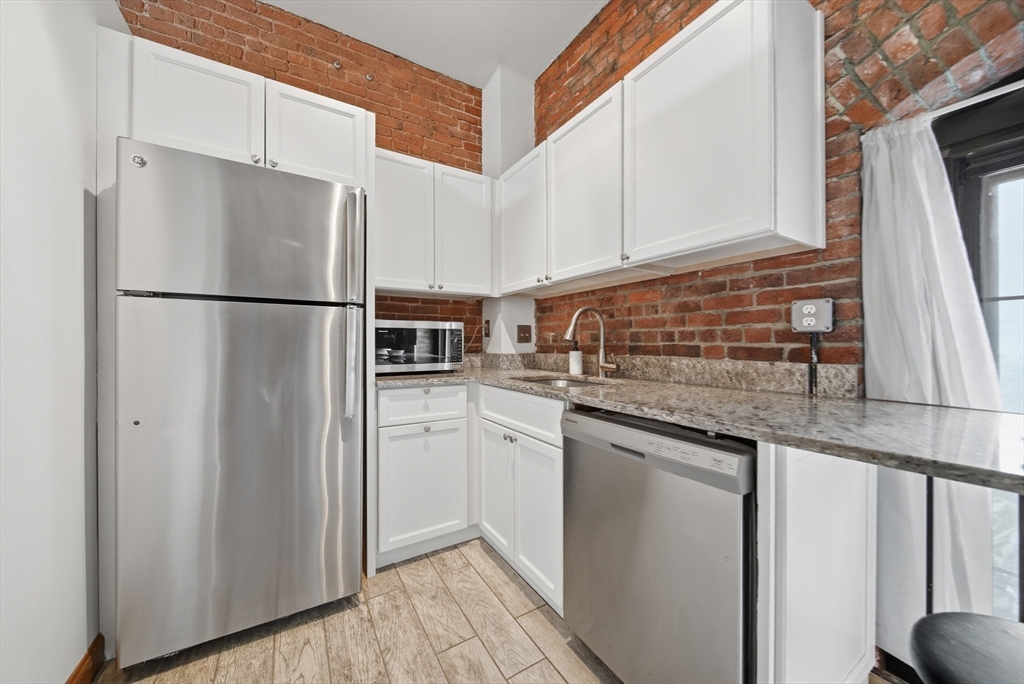 50 Rantoul Street, Unit 204 Beverly, MA 01915 - Photo 26 of 41 a kitchen with stainless steel appliances white cabinets and a refrigerator