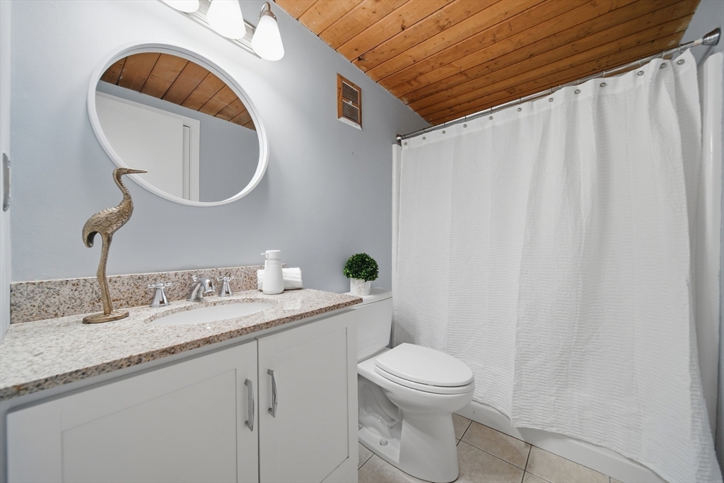 50 Rantoul Street, Unit 204 Beverly, MA 01915 - Photo 27 of 41 a bathroom with a granite countertop sink mirror vanity and toilet