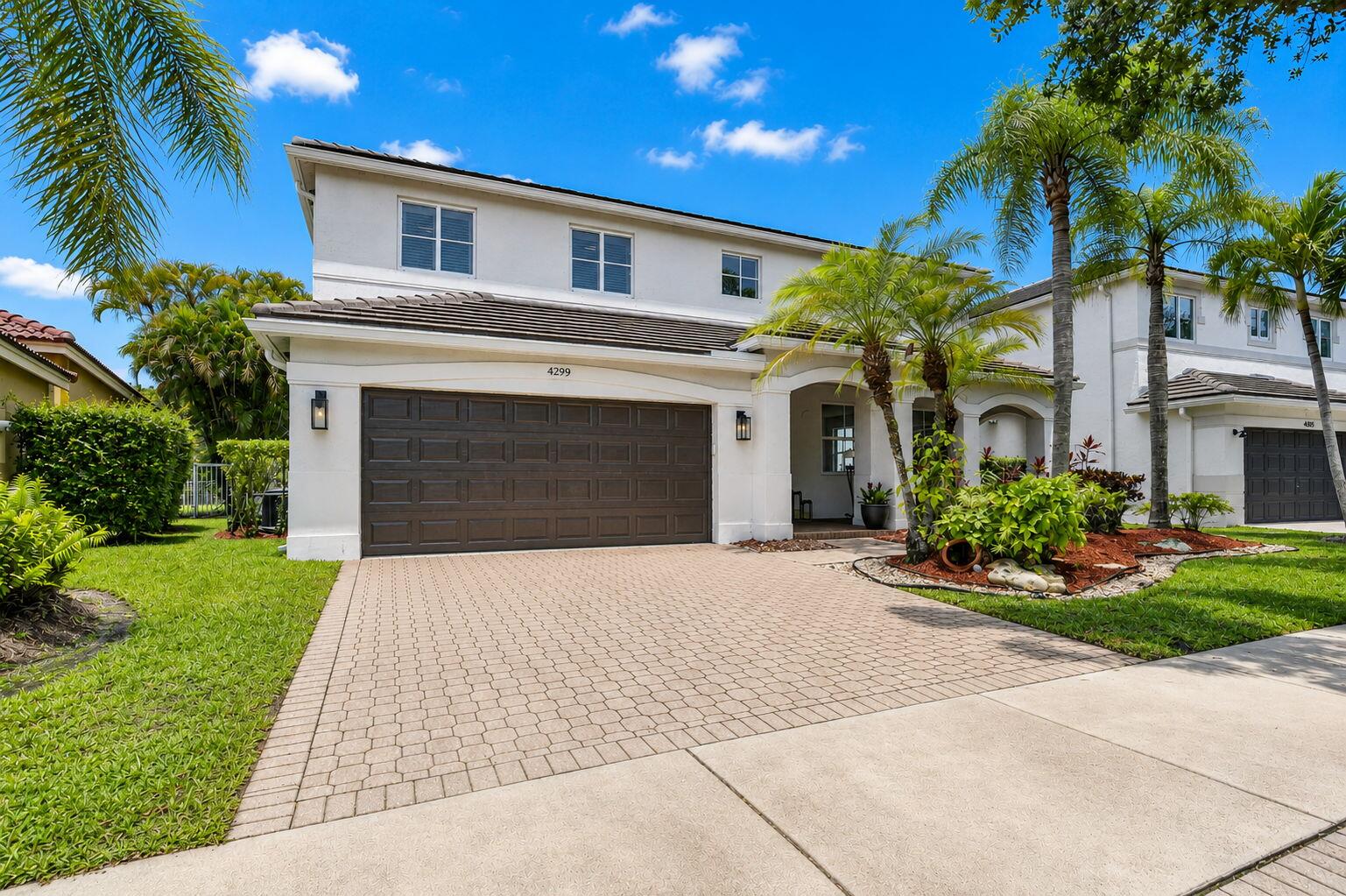4299 Laurel Ridge Circle Weston, FL 33331 - Photo 101 of 103 a front view of a house with a yard and a garage