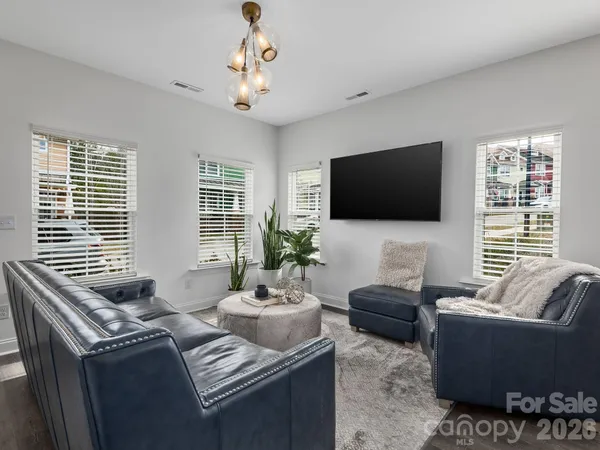a living room with furniture a flat screen tv and a large window
