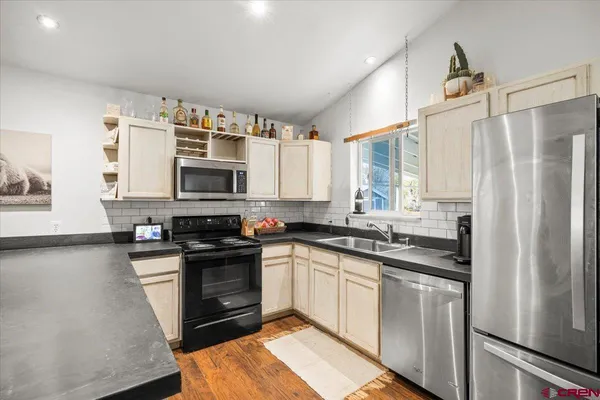 a kitchen with stainless steel appliances granite countertop a stove a sink and a refrigerator