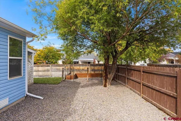 a view of a backyard with couches and wooden fence