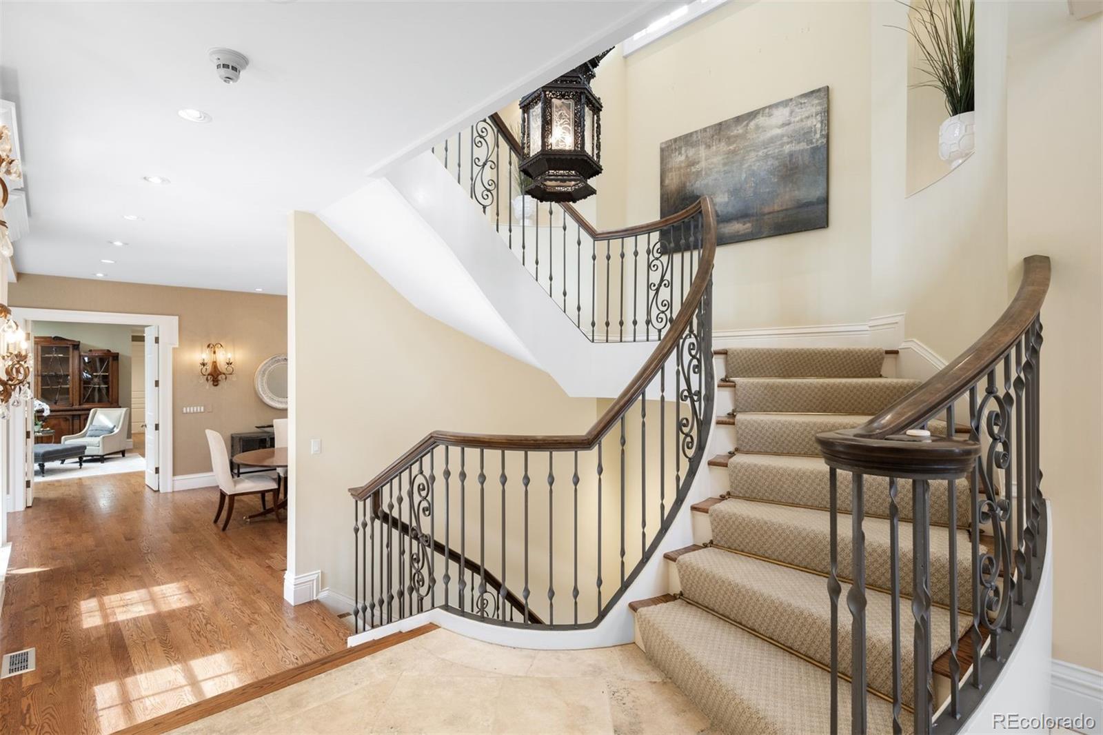 465 Monroe Street Denver, CO 80206 - Photo 8 of 47 a view of staircase with lots of frames on wall and a chandelier
