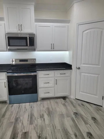 a kitchen with granite countertop a stove and a microwave oven