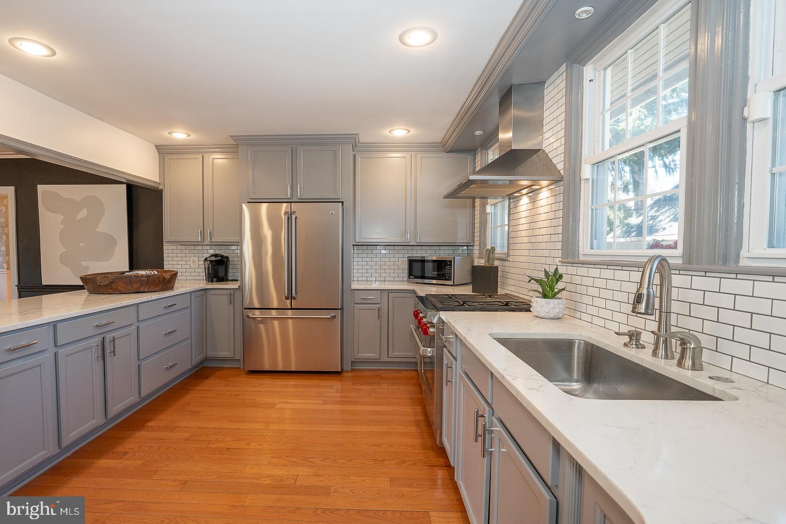 108 South Spring Mill Road Villanova, PA 19085 - Photo 12 of 53 a kitchen with a sink a refrigerator and a stove top oven with wooden floor