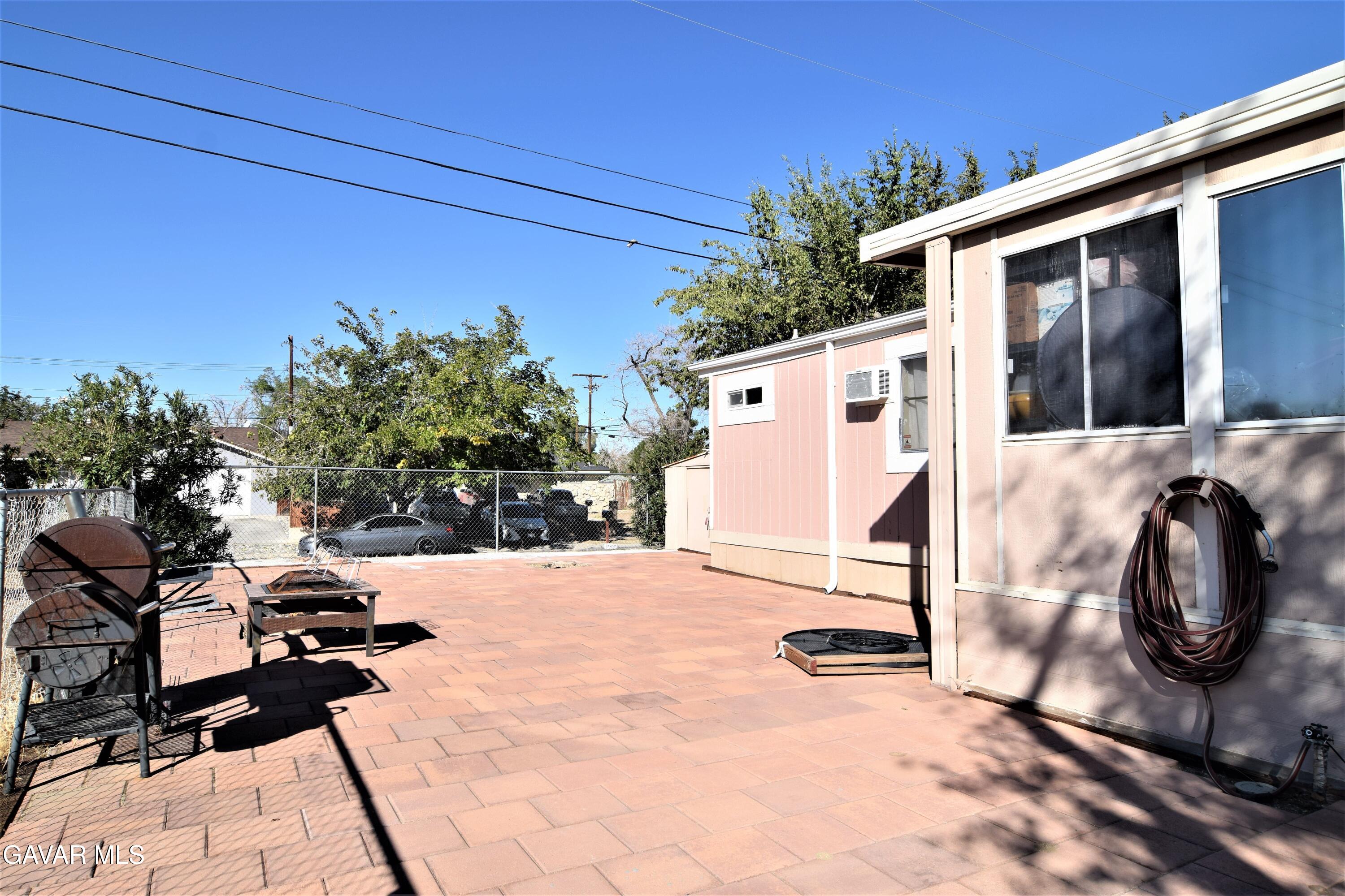 45446 7th Street East Lancaster, CA 93535 - Photo 3 of 21 a view of a patio with table and chairs and potted plants
