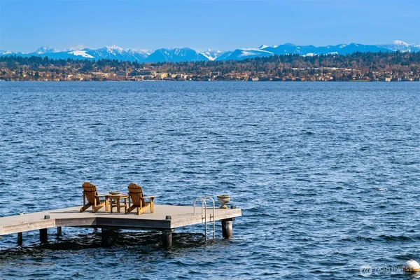 a swimming pool with outdoor seating and lake