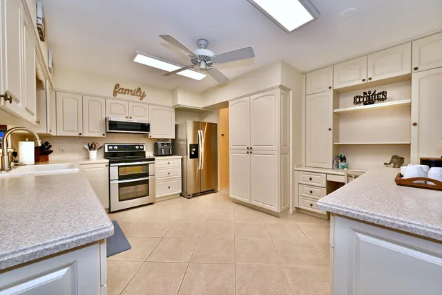 a kitchen with granite countertop a refrigerator oven a sink and dishwasher
